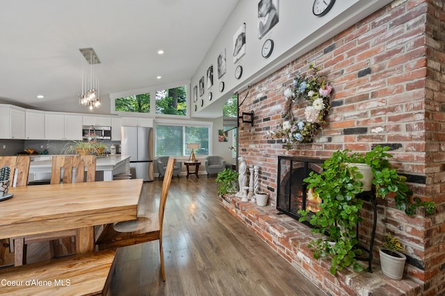 3593 W Fairway Dr, Coeur Dalene, ID 83815 - dining space featuring a fireplace, hardwood / wood-style floors, a chandelier, and recessed lighting
