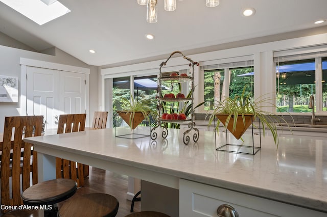 3593 W Fairway Dr, Coeur Dalene, ID 83815 - kitchen with recessed lighting, light stone countertops, a skylight, lofted ceiling, and a breakfast bar area