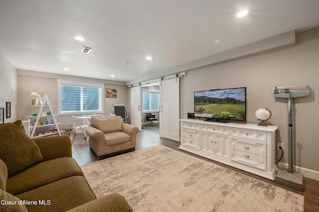 3593 W Fairway Dr, Coeur Dalene, ID 83815 - living area featuring a barn door, wood finished floors, baseboards, and recessed lighting