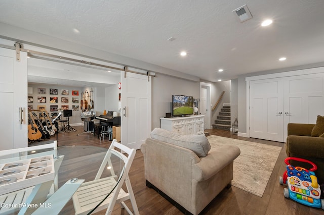 3593 W Fairway Dr, Coeur Dalene, ID 83815 - living area with a barn door, wood finished floors, recessed lighting, stairs, and baseboards