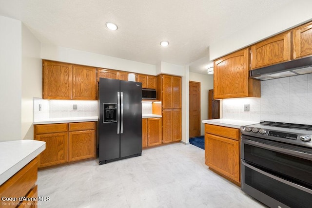 8416 N Haye Ln, Newman Lake, WA 99025 - kitchen with black refrigerator with ice dispenser, double oven range, under cabinet range hood, light countertops, and brown cabinetry