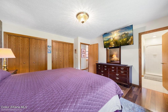 8416 N Haye Ln, Newman Lake, WA 99025 - bedroom featuring wood finished floors, two closets, a textured ceiling, and baseboards