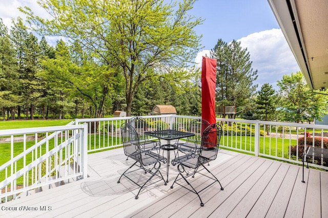 8416 N Haye Ln, Newman Lake, WA 99025 - wooden terrace with outdoor dining area, a lawn, and view of scattered trees