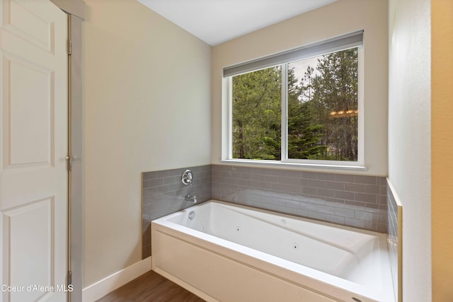 53 Koyokuk Trl, Spirit Lake, ID 83869 - full bath featuring a tub with jets, healthy amount of natural light, baseboards, and wood finished floors