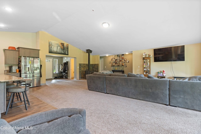 53 Koyokuk Trl, Spirit Lake, ID 83869 - living area with light wood finished floors, vaulted ceiling, and a wood stove