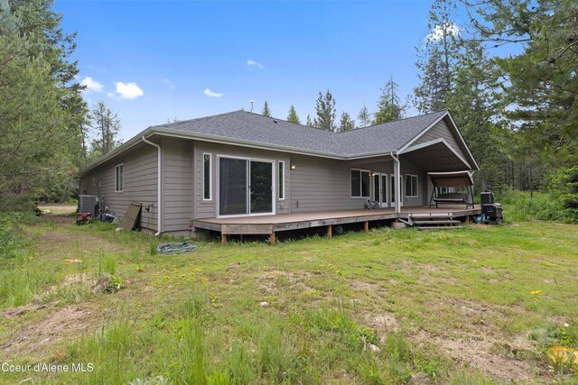 53 Koyokuk Trl, Spirit Lake, ID 83869 - rear view of property featuring cooling unit, a wooden deck, a yard, and a shingled roof