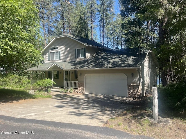 11019 W Crystal Bay Rd, Post Falls, ID 83854 - view of front of property featuring an attached garage, a porch, stone siding, and driveway