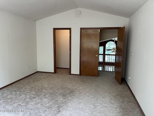 11019 W Crystal Bay Rd, Post Falls, ID 83854 - empty room with lofted ceiling, carpet flooring, ceiling fan, baseboards, and a smoke detector