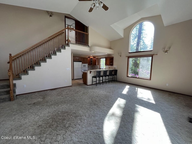 11019 W Crystal Bay Rd, Post Falls, ID 83854 - living room featuring high vaulted ceiling, carpet flooring, stairway, and a ceiling fan