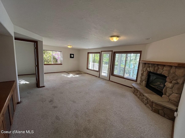 11019 W Crystal Bay Rd, Post Falls, ID 83854 - unfurnished living room featuring a fireplace, carpet flooring, a textured ceiling, and baseboards