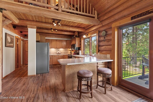 2609 W Seasons Rd, Athol, ID 83801 - kitchen featuring stainless steel appliances, light countertops, a peninsula, light wood-type flooring, and wooden ceiling with exposed beams