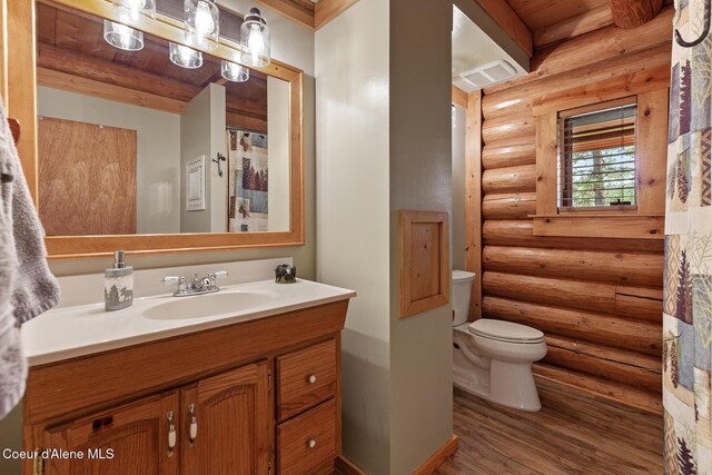2609 W Seasons Rd, Athol, ID 83801 - bathroom with log walls, toilet, vanity, wood finished floors, and wooden ceiling
