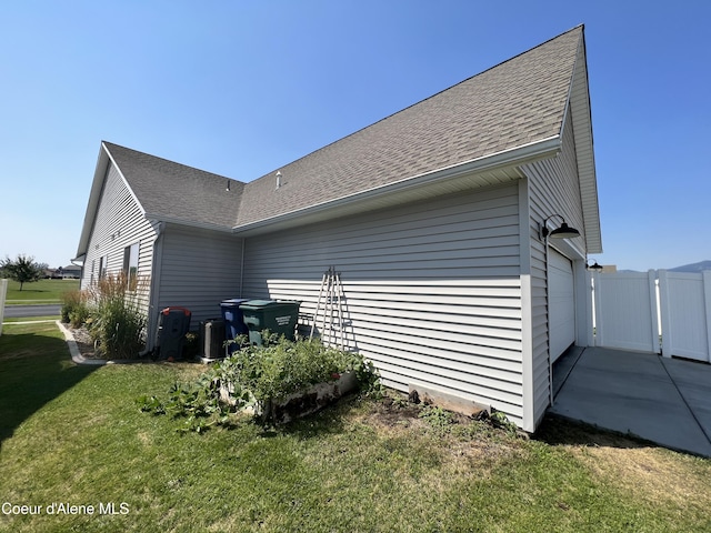 8638 N Spokane St, Post Falls, ID 83854 - view of side of home featuring a yard and roof with shingles