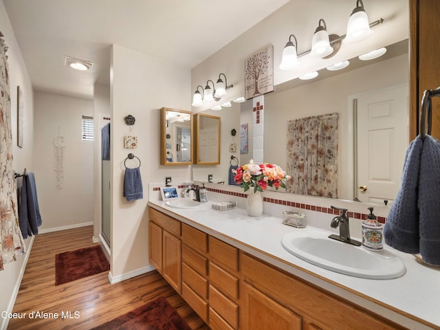 26370 S Hinds Dr, Saint Maries, ID 83861 - full bath featuring wood finished floors, double vanity, baseboards, and a shower with door