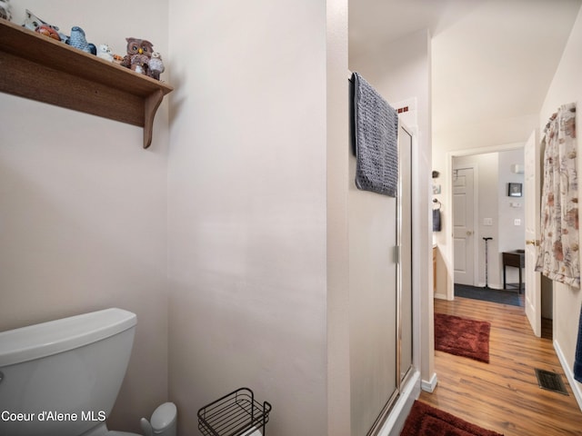 26370 S Hinds Dr, Saint Maries, ID 83861 - bathroom with toilet, a stall shower, wood finished floors, and baseboards