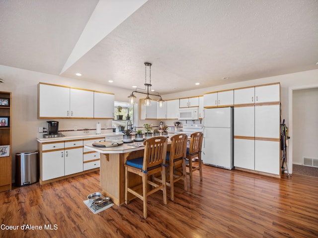26370 S Hinds Dr, Saint Maries, ID 83861 - kitchen with white appliances, white cabinetry, recessed lighting, and a textured ceiling