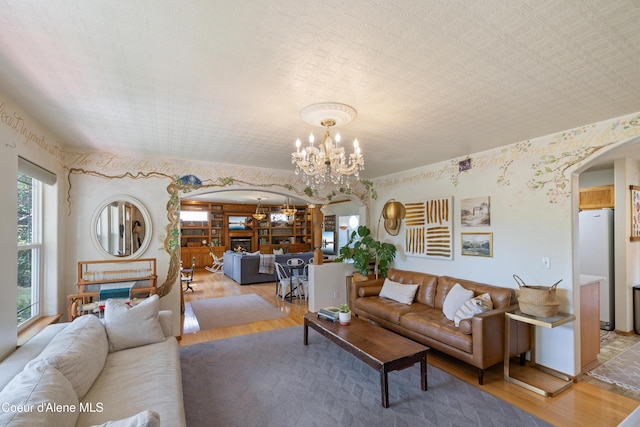 7260 N Courcelles Pkwy, Coeur Dalene, ID 83815 - living area with arched walkways, light wood-style floors, and a chandelier