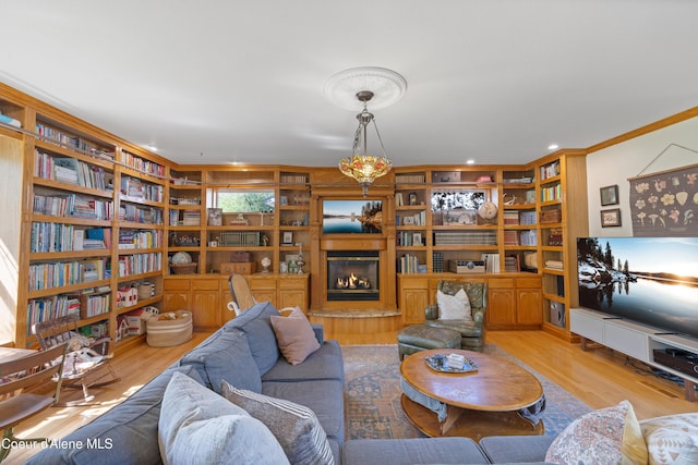 7260 N Courcelles Pkwy, Coeur Dalene, ID 83815 - living area featuring wood finished floors, ornamental molding, a glass covered fireplace, and built in features