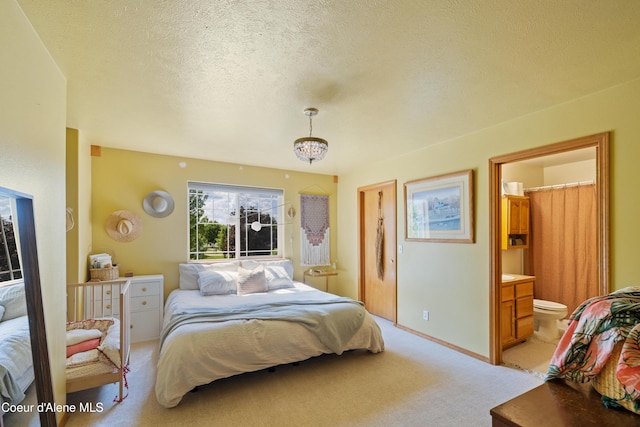 7260 N Courcelles Pkwy, Coeur Dalene, ID 83815 - bedroom featuring light carpet, ensuite bath, a textured ceiling, and a chandelier