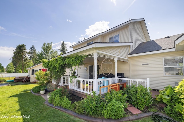 7260 N Courcelles Pkwy, Coeur Dalene, ID 83815 - rear view of property featuring a lawn and covered porch