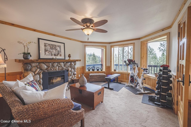 15964 N Songbird Ln, Rathdrum, ID 83858 - carpeted living room with wainscoting, crown molding, a fireplace, a ceiling fan, and wooden walls