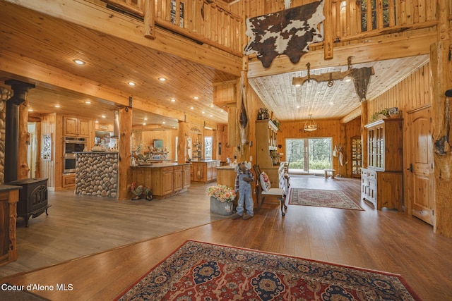 15964 N Songbird Ln, Rathdrum, ID 83858 - living area with light wood finished floors, wood walls, wooden ceiling, and a wood stove
