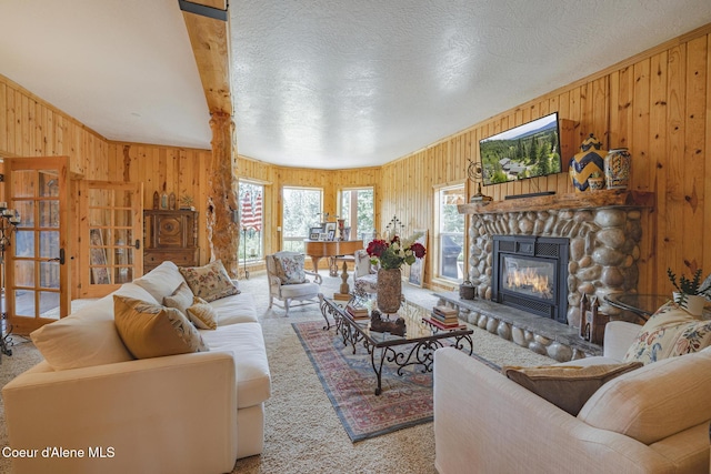 15964 N Songbird Ln, Rathdrum, ID 83858 - living room featuring wood walls, carpet floors, a stone fireplace, and a textured ceiling