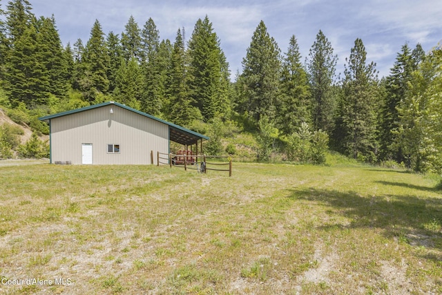 15964 N Songbird Ln, Rathdrum, ID 83858 - view of grassy yard with a pole building, an outdoor structure, and a wooded view