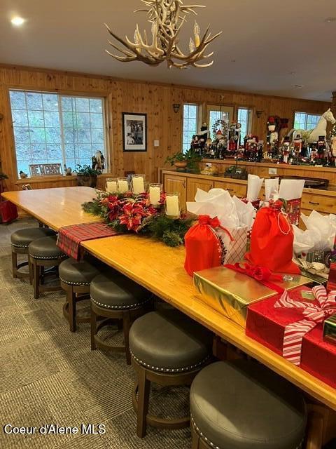 15964 N Songbird Ln, Rathdrum, ID 83858 - dining area with a chandelier, wooden walls, healthy amount of natural light, and carpet floors