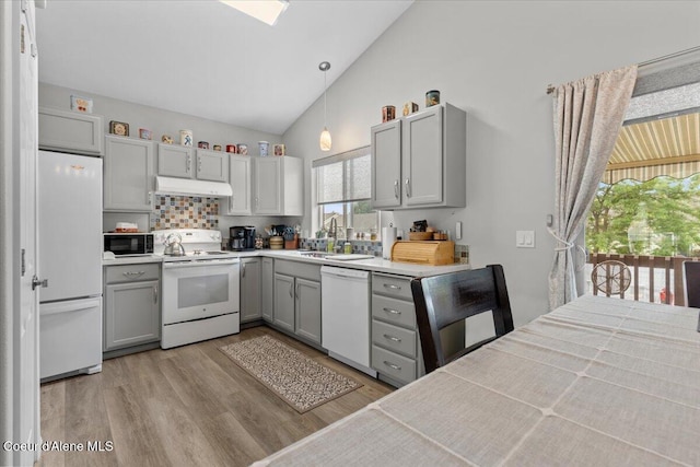 2574 W Sarge Ct, Coeur Dalene, ID 83815 - kitchen featuring white appliances, gray cabinets, under cabinet range hood, light wood-type flooring, and high vaulted ceiling