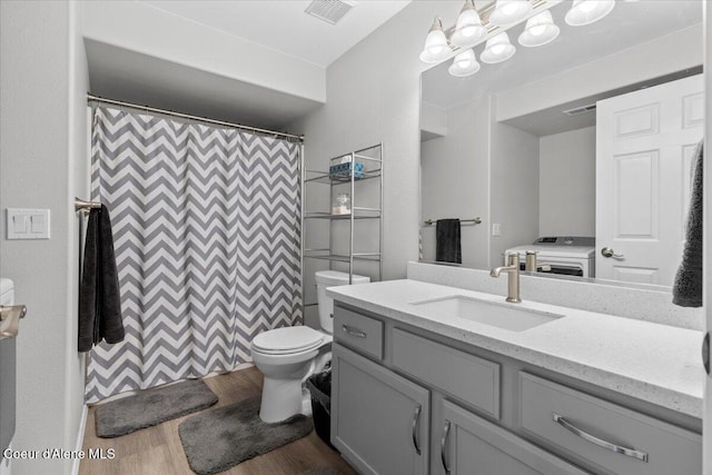 2574 W Sarge Ct, Coeur Dalene, ID 83815 - full bathroom featuring toilet, wood finished floors, vanity, washer / dryer, and a shower with shower curtain