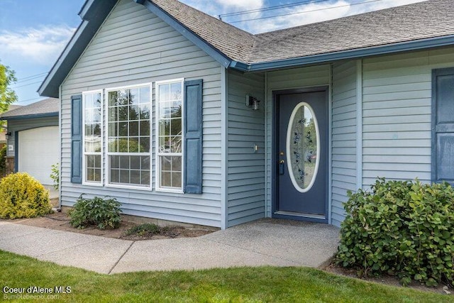 1555 W Benjamin Ave, Coeur Dalene, ID 83815 - doorway to property featuring a shingled roof and a garage