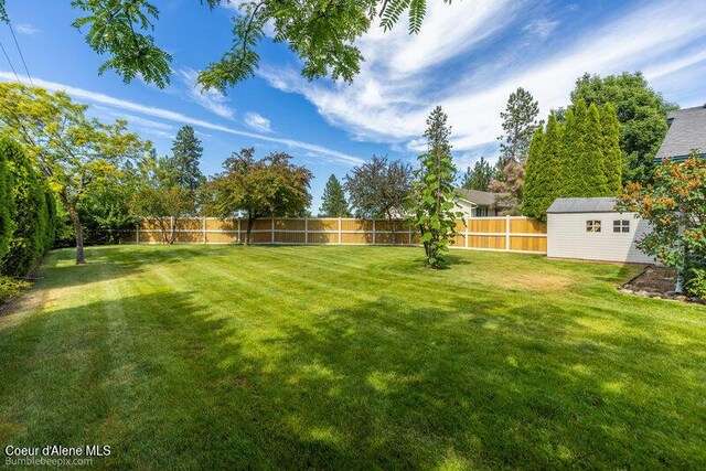 1555 W Benjamin Ave, Coeur Dalene, ID 83815 - fenced backyard featuring a storage unit
