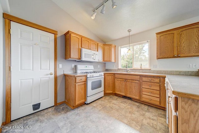 1555 W Benjamin Ave, Coeur Dalene, ID 83815 - kitchen with white appliances, vaulted ceiling, light countertops, hanging light fixtures, and rail lighting