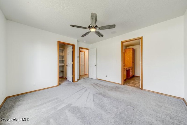 1555 W Benjamin Ave, Coeur Dalene, ID 83815 - unfurnished bedroom featuring light carpet, a spacious closet, a textured ceiling, and a ceiling fan