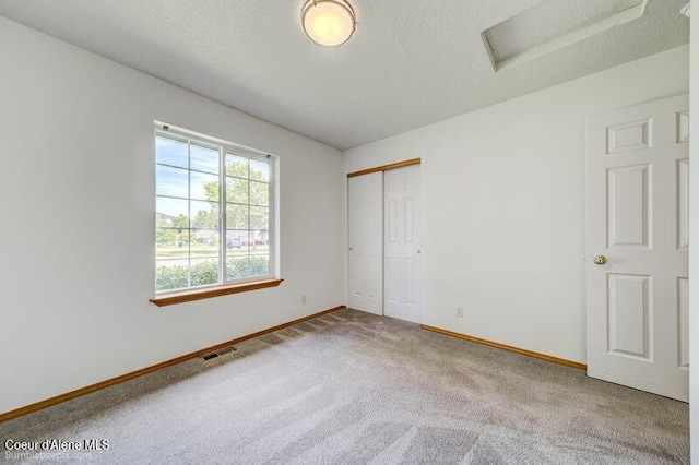 1555 W Benjamin Ave, Coeur Dalene, ID 83815 - unfurnished bedroom with attic access, carpet, and a closet