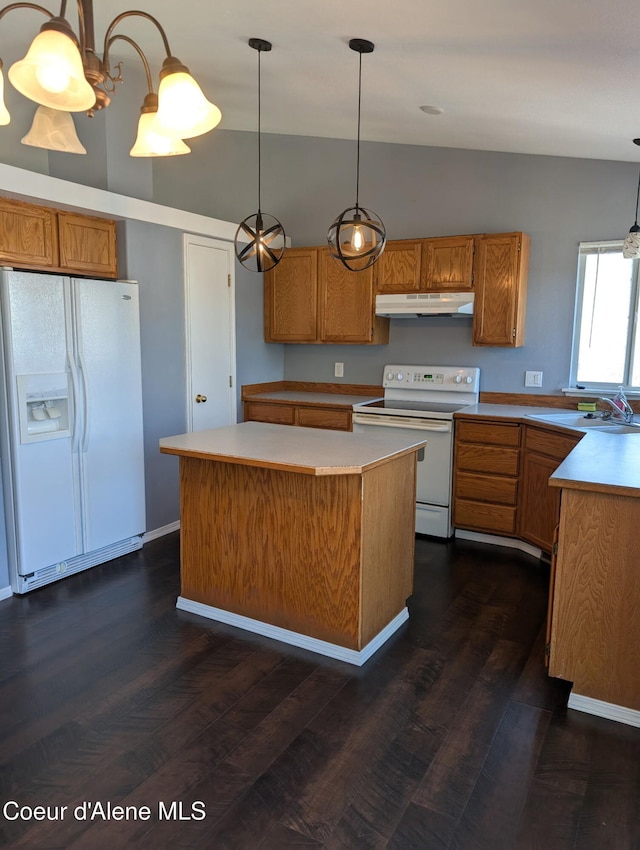 902 E Glacier Peak Dr, Post Falls, ID 83854 - kitchen with white appliances, under cabinet range hood, vaulted ceiling, dark wood-style flooring, and light countertops