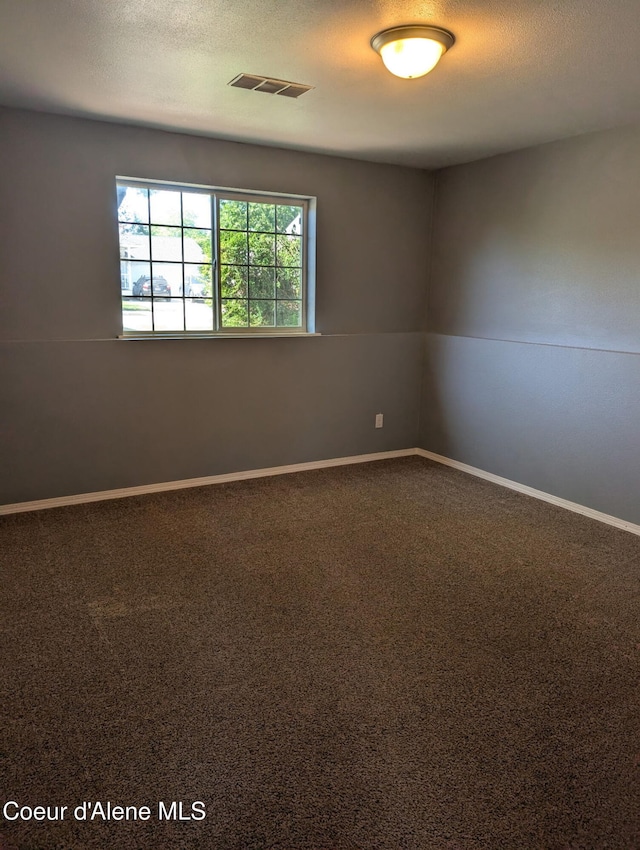 902 E Glacier Peak Dr, Post Falls, ID 83854 - unfurnished room featuring dark carpet, a textured ceiling, and baseboards