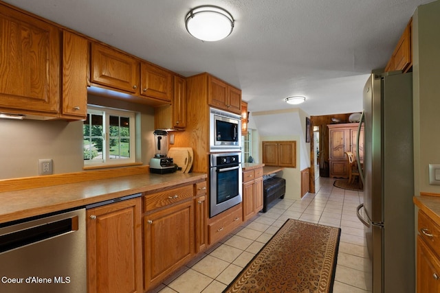 343 W Spring Creek Rd, Hope, ID 83836 - kitchen featuring appliances with stainless steel finishes, brown cabinetry, and light tile patterned floors