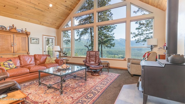 75 Windy Ln, Moyie Springs, ID 83845 - living room featuring carpet flooring, wooden ceiling, high vaulted ceiling, a mountain view, and baseboards