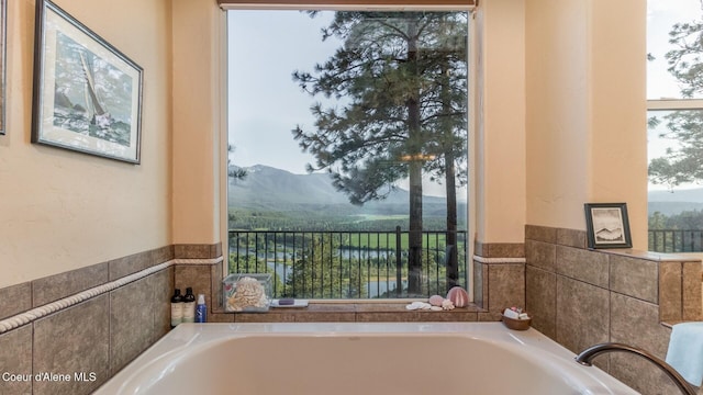 75 Windy Ln, Moyie Springs, ID 83845 - full bath with a garden tub, a mountain view, and a wainscoted wall