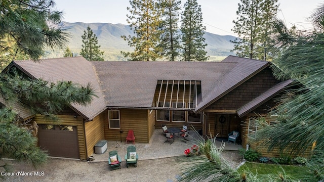 75 Windy Ln, Moyie Springs, ID 83845 - view of front of property with a mountain view, a patio, and an attached garage