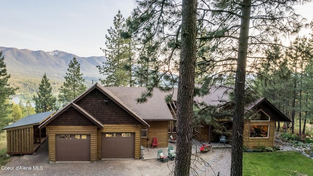 75 Windy Ln, Moyie Springs, ID 83845 - log cabin featuring an attached garage, a mountain view, and gravel driveway