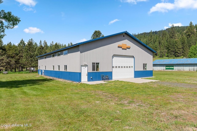 26277 N Chevrolane Way, Rathdrum, ID 83858 - view of pole building with a lawn and a view of trees