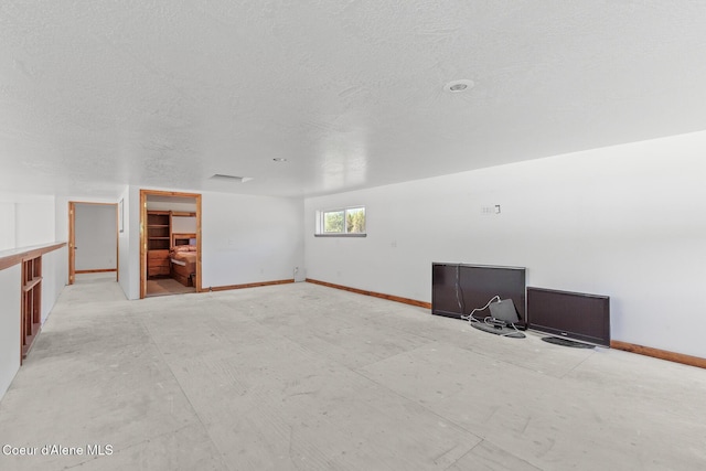26277 N Chevrolane Way, Rathdrum, ID 83858 - unfurnished living room featuring baseboards and a textured ceiling