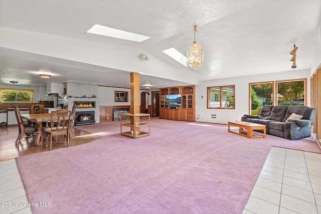 26277 N Chevrolane Way, Rathdrum, ID 83858 - living room with a fireplace, lofted ceiling, plenty of natural light, a skylight, and light tile patterned flooring