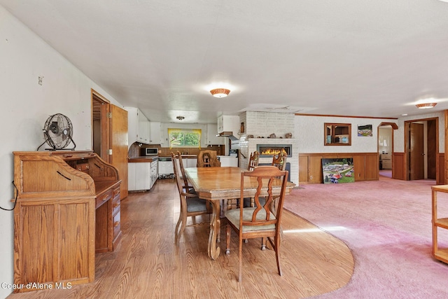 26277 N Chevrolane Way, Rathdrum, ID 83858 - dining space featuring a brick fireplace and light wood-style floors