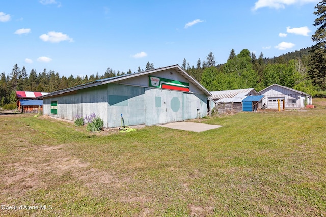 26277 N Chevrolane Way, Rathdrum, ID 83858 - back of house featuring a lawn and a forest view