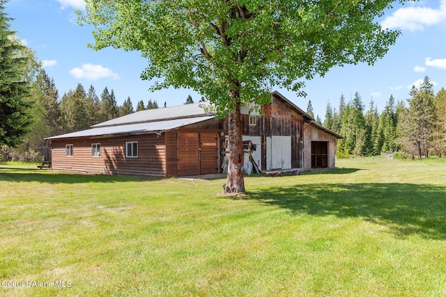 26277 N Chevrolane Way, Rathdrum, ID 83858 - rear view of house featuring a lawn, an outdoor structure, a barn, and a garage
