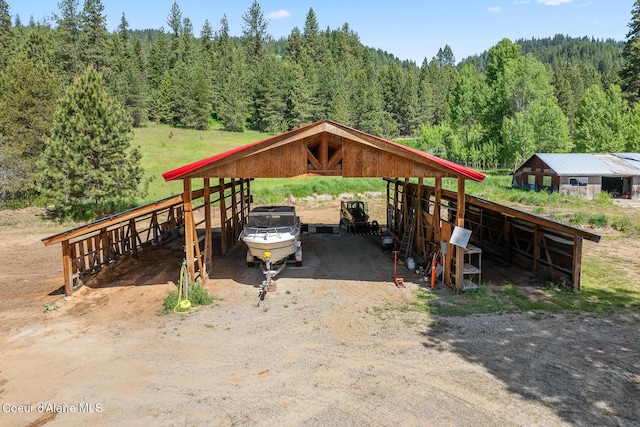 26277 N Chevrolane Way, Rathdrum, ID 83858 - view of parking with a forest view, a detached carport, and driveway